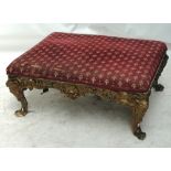 A large 19th century giltwood stool with upholstered padded seat and C foliate scroll frame on mask