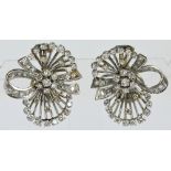 A pair of white metal diamond set ribbon tied floral spray earrings, each with pierced framework,