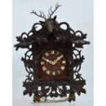 A carved oak cuckoo clock, the circular dial set with applied Roman numerals,