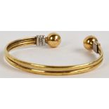 A 9ct two tone gold bangle, approx 11.6g. CONDITION REPORT: The oval is approx 6.