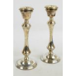 A pair of Elizabeth II hallmarked silver candlesticks with bell shaped sconces and detachable