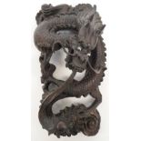 A late 19th/early 20th century Chinese carved wooden dragon chasing the pearl of wisdom,