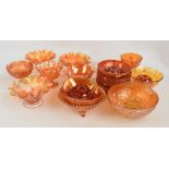 A group of orange carnival glass bowls to include circular floral and foliate decorated examples