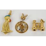 Three 9ct gold charms; pair of binoculars, circular pendant and a parrot, combined approx 6.1g.