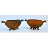 A pair of small cast iron twin handled garden urns of oval form with gadrooned body on four