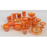A group of various orange carnival glass items to include a two-part punch bowl with a set of six