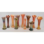 A group of orange carnival glass waisted vases with shaped rims,