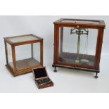 A case for a set of laboratory scales and a further glazed case (2).