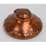 A French Arts and Crafts copper inkwell of domed form with hinged lid enclosing a glass liner