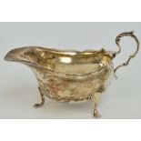 An Edward VII hallmarked silver sauce boat with shaped rim and C-scroll handle,