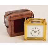 A 20th century brass cased rectangular carriage clock with swing loop handle above white enamel