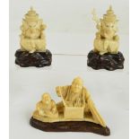 A Japanese Meiji period carved ivory figure group depicting a seated street seller with a child