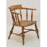 A late 19th century elm seated smoker's bow elbow chair with turned spindle supports.