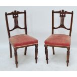 A set of four Edwardian walnut dining chairs with padded seats and ring turned front legs.