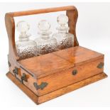 An Edwardian oak tantalus with three clear hobnail cut decanters (af) with twin hinged