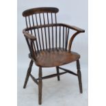 A mid 19th century country made ash and elm rustic low back spindle Windsor type elbow chair with