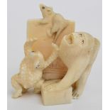 A Japanese Meiji period carved ivory figure group depicting a monkey,