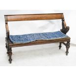 A Victorian mahogany bench with fixed top rail and twin carved pivoting end supports allowing