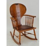A stained beech rocking chair with shaped back and spindle supports