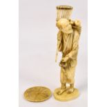 A Japanese Meiji period carved ivory okimono depicting a fruit gatherer with a rake over his
