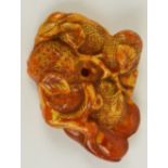 A Japanese Meiji period amber netsuke carved with pineapple and branches, approx 5.5 x 4cm, 11.8g.