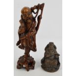 A Chinese rootwood carving of Lohan carrying a branch with bead necklace and with a tassel,