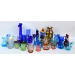 A quantity of coloured glass, predominantly jugs, also several vases, figure of a clown, etc.