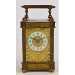 A late 19th century French brass carriage clock with fluted corners surmounted with cast finials,