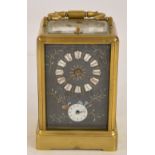 A brass carriage clock with swing loop handle above rectangular enamel dial set with Roman numerals