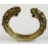 A Tibetan white metal dragon decorated bangle, width 7.5cm.