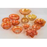 A collection of orange carnival glass dishes and small bowls to include oval fluted examples,