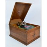 An oak cased HMV gramophone with sound openings to the front.