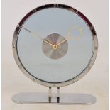 An Art Deco chrome and clear glass circular clock with Roman numerals to the outer ring,