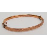 A 9ct rose gold slender snap bangle, decorated with leaves, approx 4.3g.