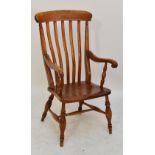A beech and elm seated kitchen Windsor elbow chair on turned supports.