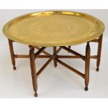A large Eastern brass circular tray/coffee table with various decorative bands of calligraphy and