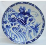 A large Japanese Meiji period blue and white painted charger decorated with a dragon, unmarked,