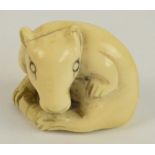 A Japanese Meiji period carved ivory netsuke modelled as a rat licking its paw and sat on its tail,