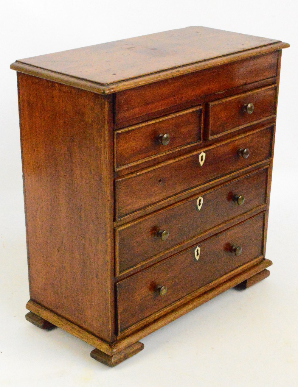 A 19th century mahogany miniature/apprentice chest of two short and three long drawers with shield