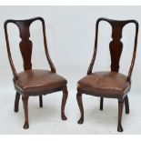 A pair of mahogany chairs with leather upholstered seats.