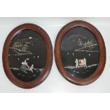 A pair of oval Meiji period Japanese lacquer panels with inset mother of pearl on black background,