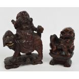 A Chinese rootwood carving depicting a man seated upon a temple lion with ivory inset teethe and