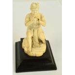 A Japanese Meiji period carved ivory figure of a seated man playing a flute,