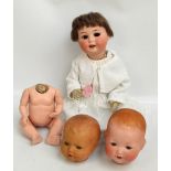 A German Heubach & Köppelsdorf bisque headed doll with open and close brown eyes detached but