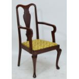 An early 20th century oak Queen Anne style upholstered elbow chair on cabriole legs with pad feet,