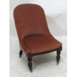 A Victorian upholstered spoon back chair raised on mahogany ring turned front legs to castors.