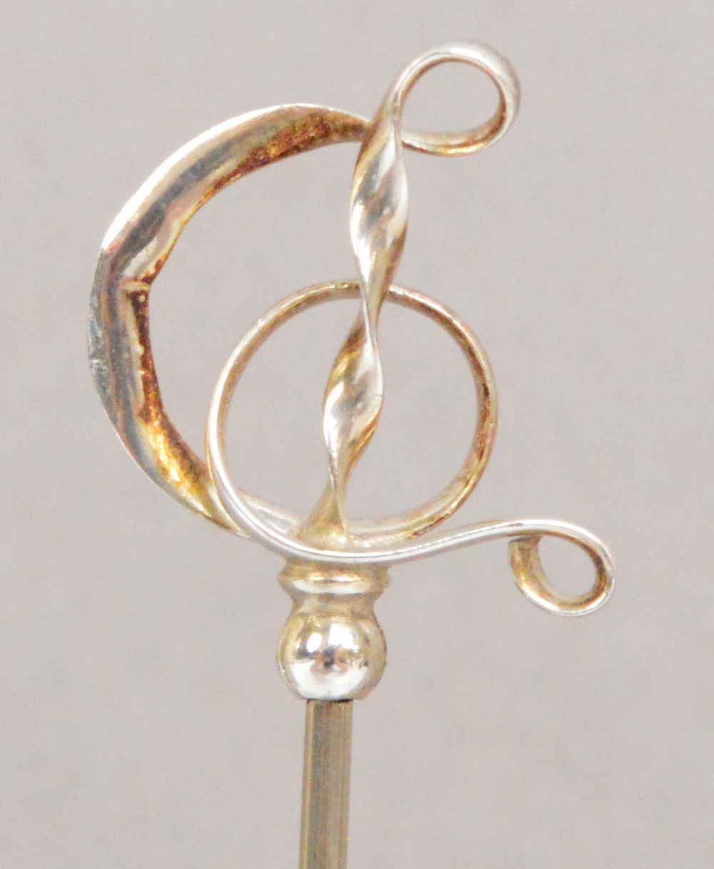 A Charles Horner hallmarked silver hat pin of abstract looped ribbon musical clef form,