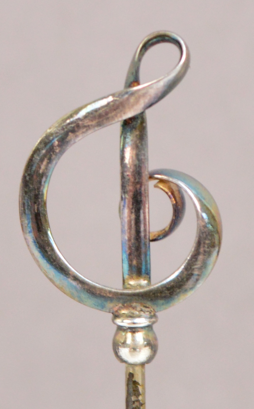 A pair of Charles Horner sterling silver hat pins in the form of looped ribbon treble clefs,