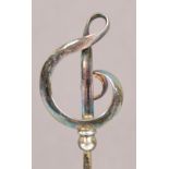 A pair of Charles Horner sterling silver hat pins in the form of looped ribbon treble clefs,