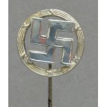 A George V hallmarked silver hat pin in the form of a fylfot within a circular wreath,